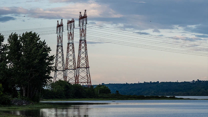 Pylônes électriques au bord d'une pièce d'eau
